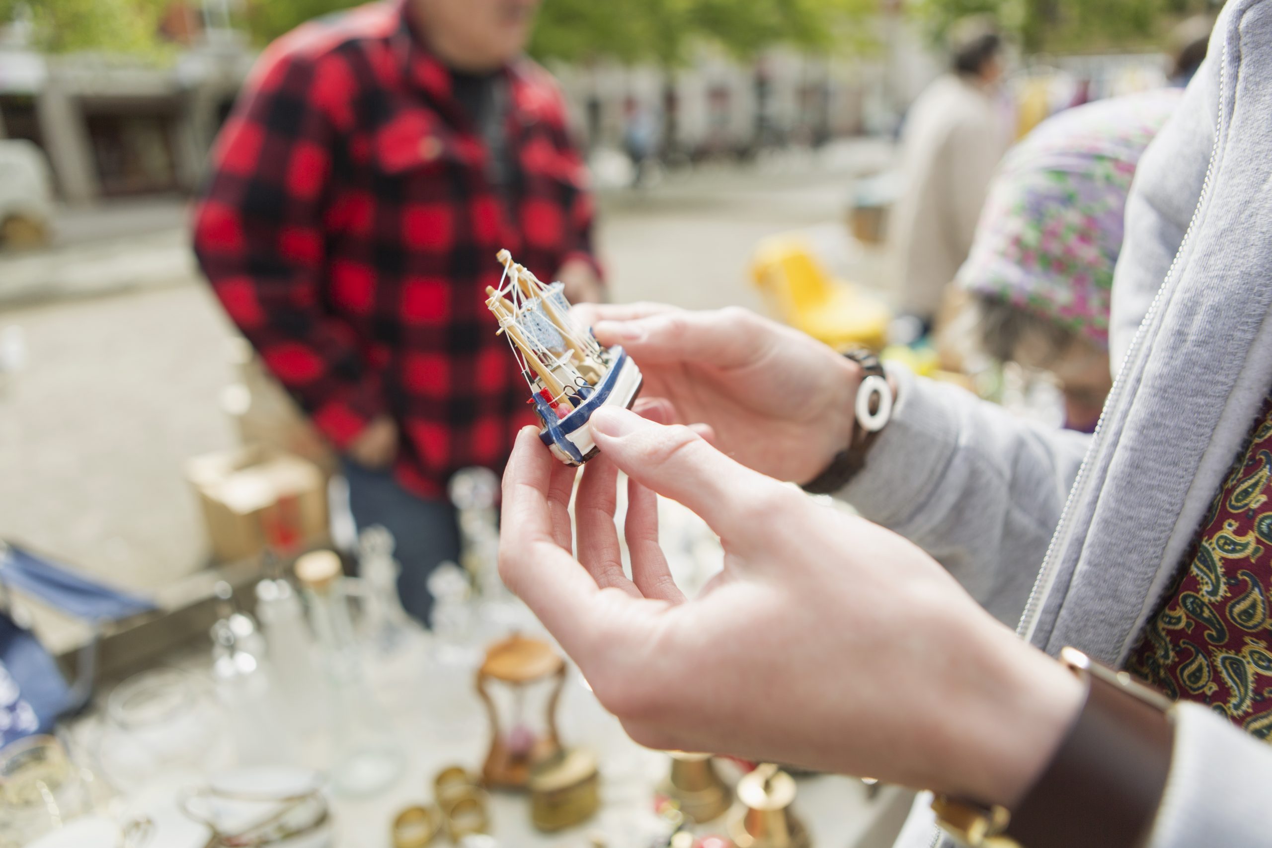 Cropped image of man holding antique ship toy at flea market